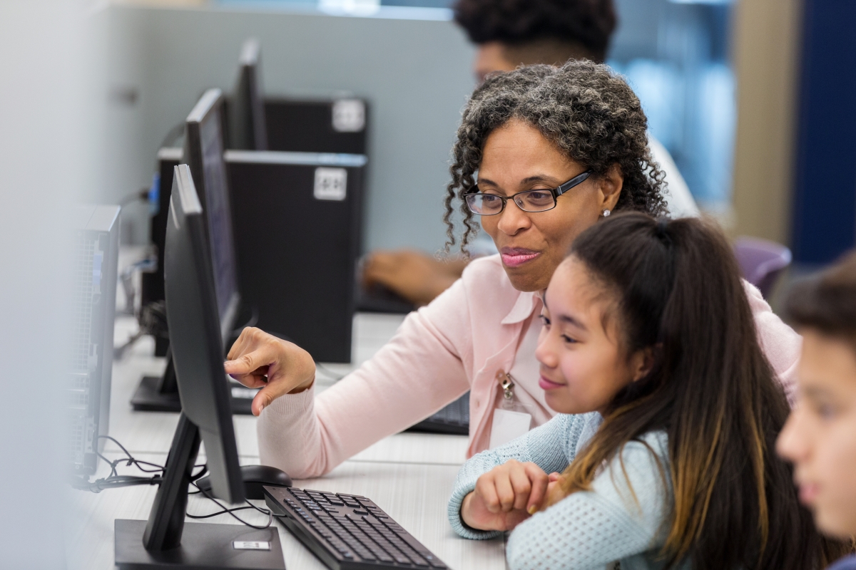 Woman teaching children at a computer